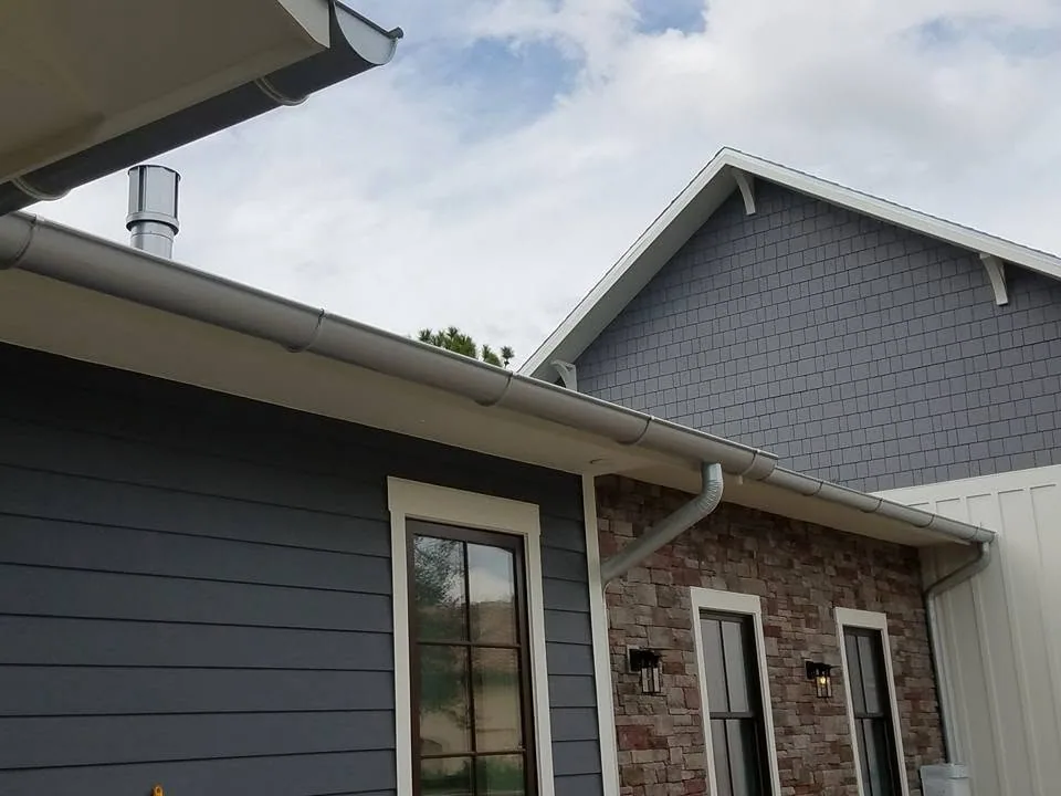 Galvanized half round gutters navy lap siding stone veneer, Sanford